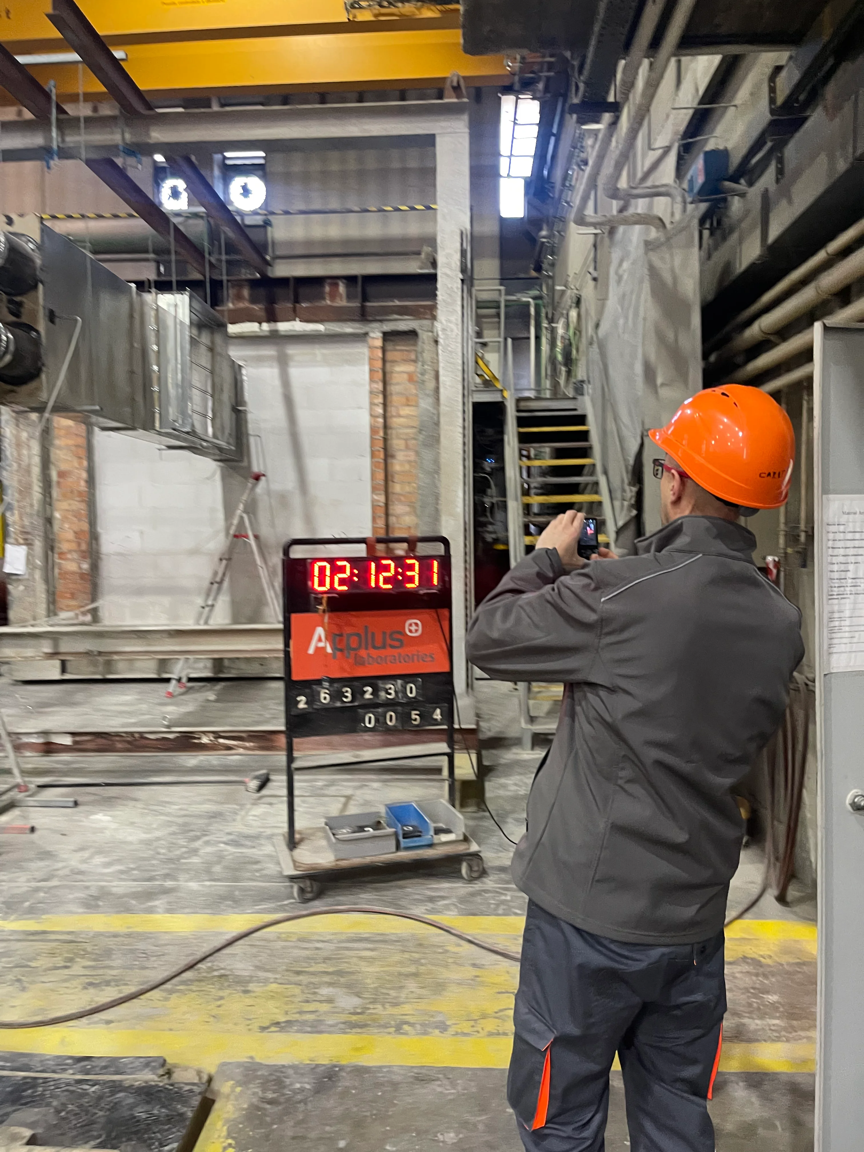 Feuertest-Setup mit einer feuchteren Montage, Digital Timer und einem Techniker, der den Test beobachtet.