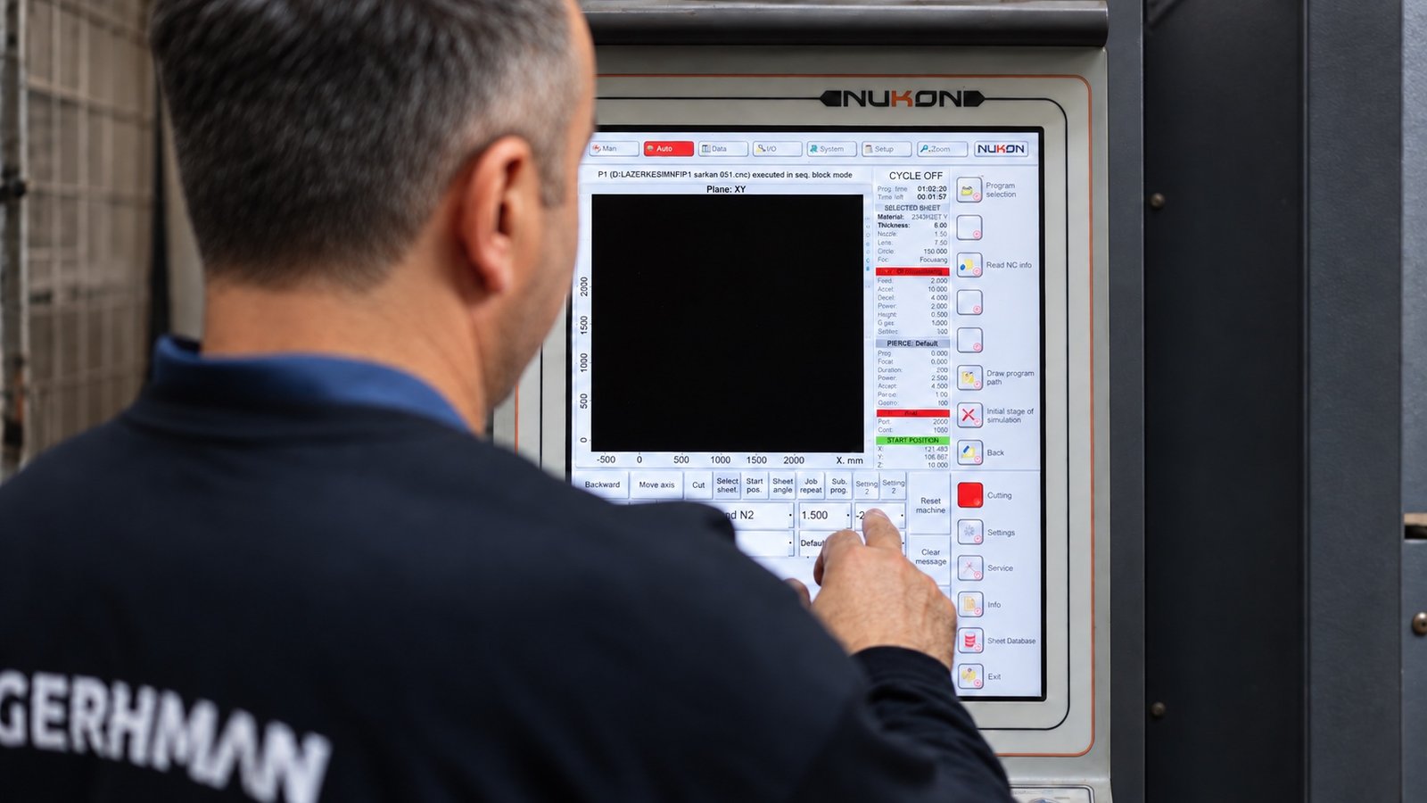 Gerhman production operator using a machine control panel.